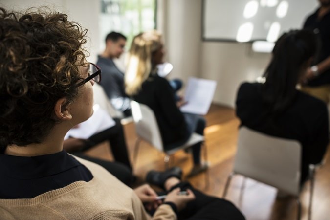 Immagine di una classe di formazione, con un primo piano un discente preso di profilo.