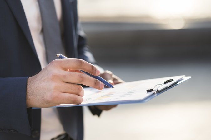 Un uomo verifica dati e informazioni su una cartellina. Simbolo della verifica dell'efficacia della formazione richiesta dal nuovo Accordo Stato Regioni.