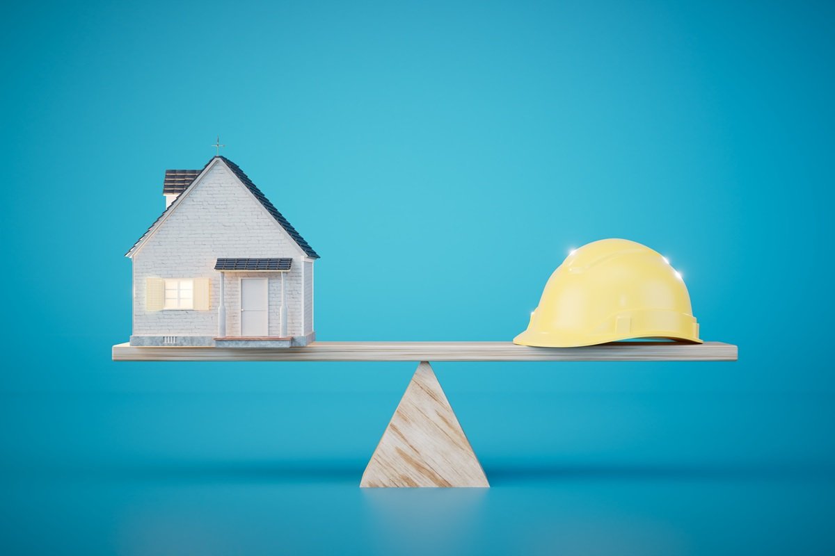 Una casa e un elmetto in equilibrio su una bilancia a indicare l'impegno richiesto dalla certificazione UNI/PdR 125 su questo argomento, anche in relazione all'equilibrio tra uomini e donne.