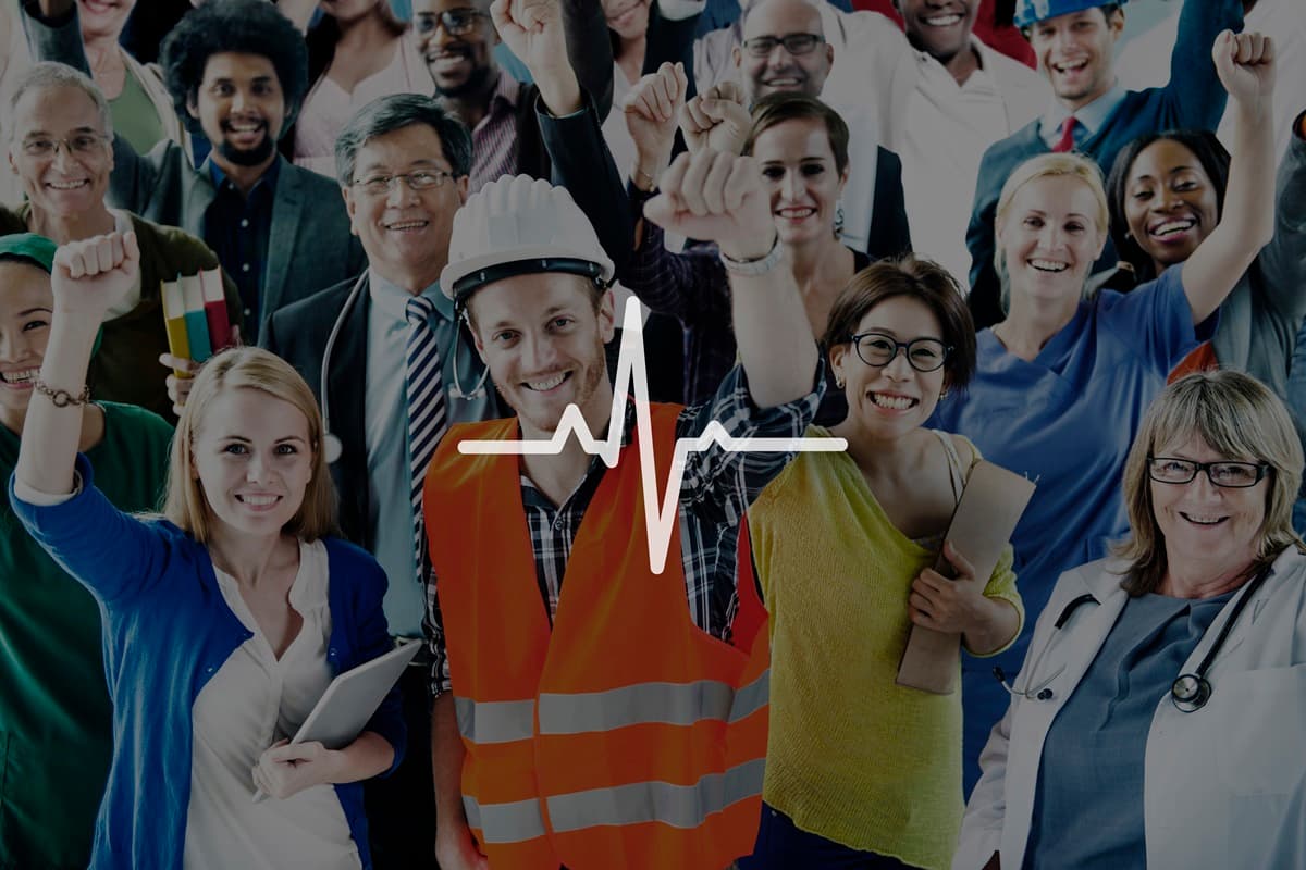 Un gruppo di persone che indossa abiti da lavoro relativi a settori diversi esulta. Un filtro scuro mette in risalto in primo piano una linea bianca che rappresenta un tratto di un elettrocardiogramma.